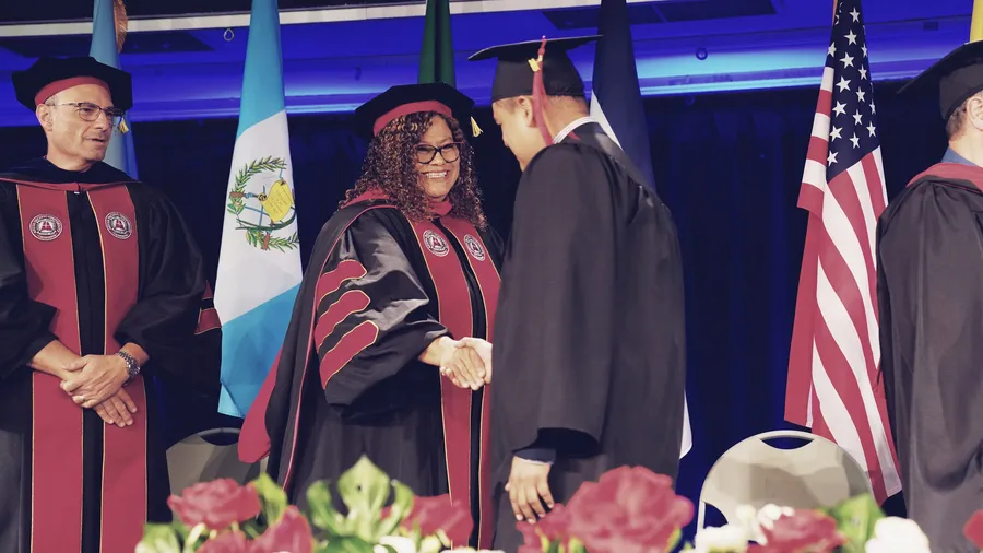 Procesión académica de graduación con las banderas de los países de origen de los estudiantes